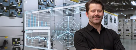 A smiling man in a black shirt with crossed arms stands before electrical panels, overlaid with transparent digital graphs and a radar display.